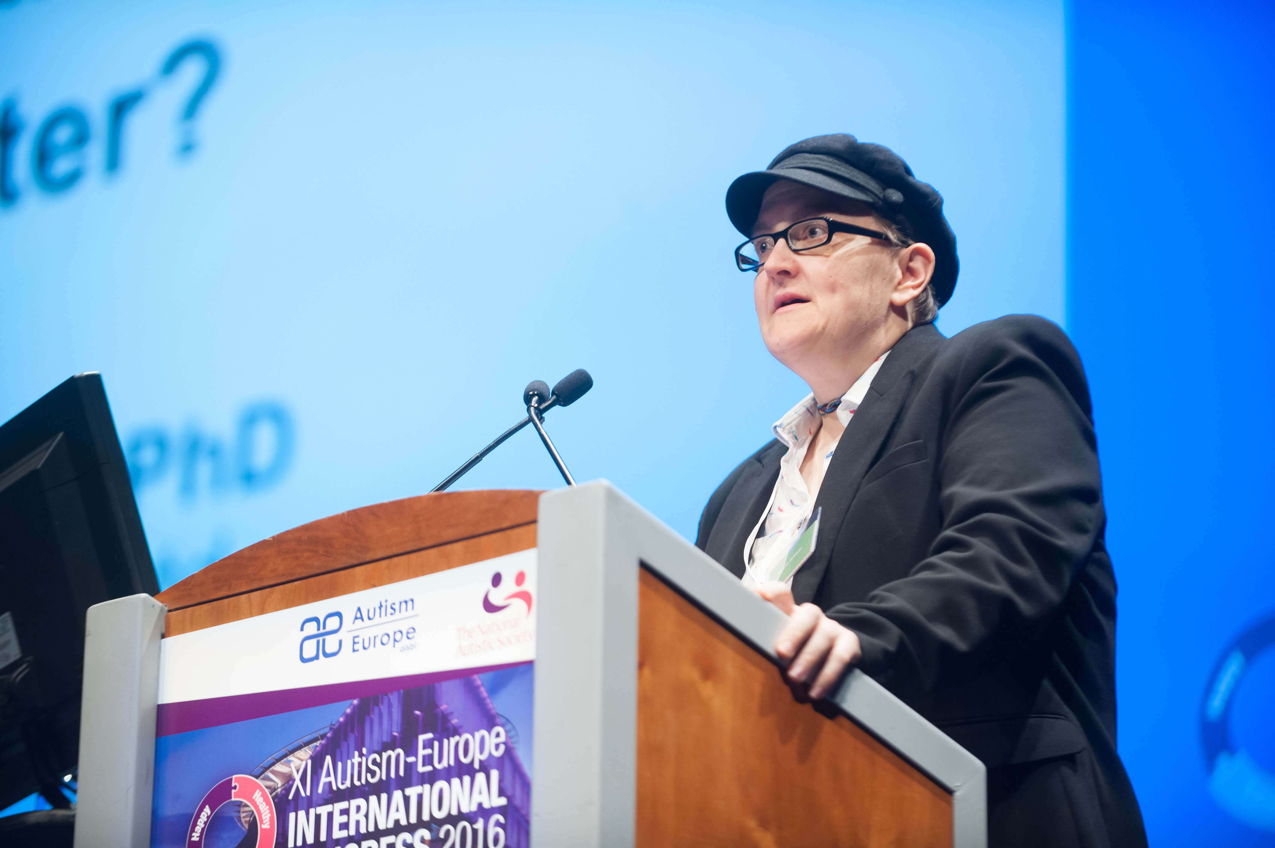 Yo Dunn speaks at the podium of the Autism Europe and National Autistic Society XI Autism-Europe International Congress 2016.